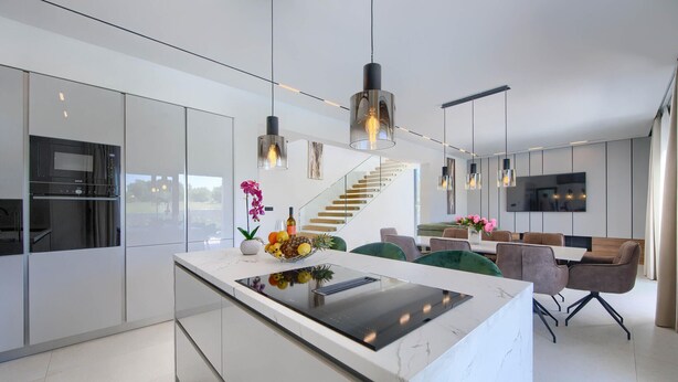 A modern kitchen with a central island, stainless steel appliances, and pendant lighting. - Amazing home in Nedescina (Nedescina)