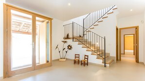 Ein modernes Interieur mit einer Treppe, Schiebeglasüren und einem Blumentopf.