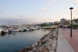 A marina with boats docked, a stone breakwater, and buildings in the background. - Apartment 'Piso Para Grupos Cerca Del Mar' with Shared Pool, Wi-Fi and Air Conditioning (Garrucha)