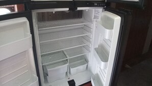 A compact refrigerator with multiple compartments, including a freezer, a main compartment, and a smaller door freezer. - Luxury 2-bedroom RV in fabulous Woodbury with WiFi, AC (Woodbury)