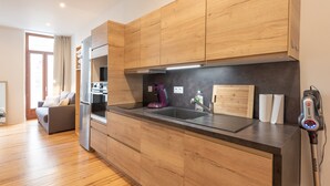 A modern kitchen with wooden cabinets, a built-in oven, and a large island with a sink.