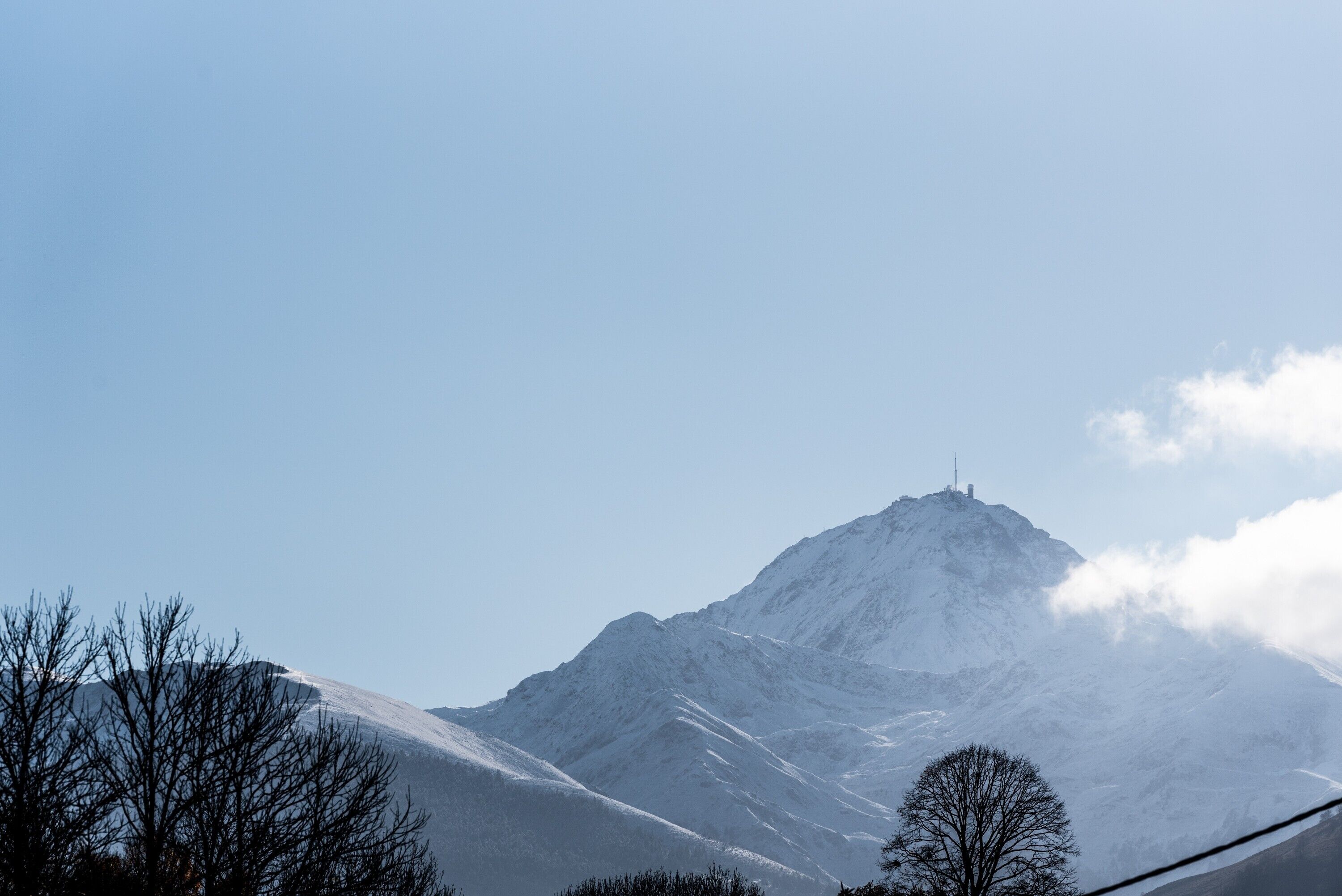 A snow-covered mountain with a clear sky.