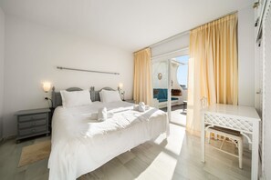Ein modernes Schlafzimmer mit einem großen Bett, Nachttischen, einem Schreibtisch und einem Stuhl.