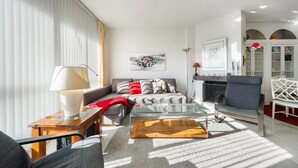 Een moderne woonkamer met een bank, een glazen salontafel en een open haard.