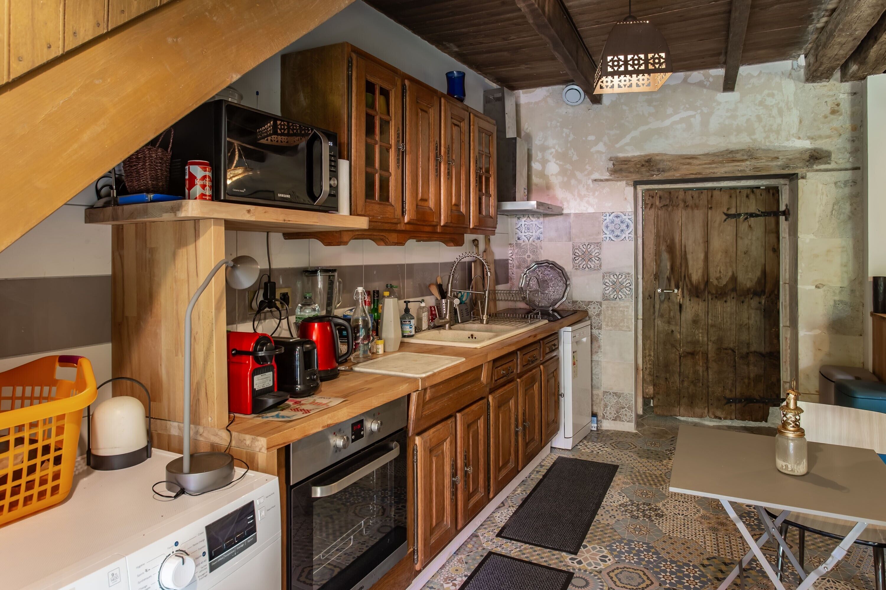 Una cucina con mobili in legno, un forno a microonde, un lavello e un piano cottura.