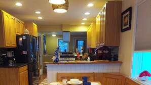 A kitchen with wooden cabinets, a dining table set for four, and a refrigerator with a Buffalo logo.