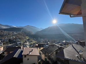 A village with traditional architecture, a church, and mountains in the background.