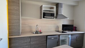 Una cucina moderna con forno a microonde integrato, lavastoviglie e lavello.