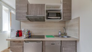 Een moderne keuken met een magnetron, spoelbak en vaatwasser.