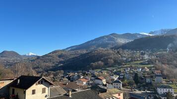 Une ville à l’architecture traditionnelle, avec une montagne en arrière-plan et un ciel dégagé.