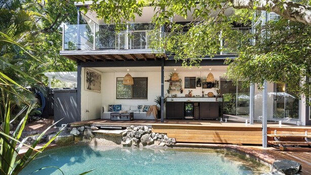 A modern house with a swimming pool, a wooden deck, and a balcony overlooking the pool. - Noosa Heads House. Resort style pool, surrounded by tropical gardens. Location! (Noosa Heads)