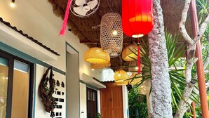 A traditional wooden structure with thatched roofing, bamboo furniture, and hanging red lanterns. - Homestay Ngô Khánh 1 (Da Nang)
