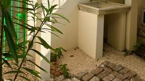 A staircase with green railings, a window with horizontal bars, and a small sink area. - Casa Chulibul located in downtown Merida, a fusion of tradition and comfort. (Centro)