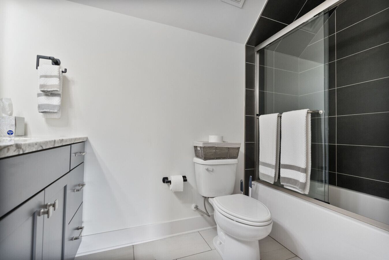 Ein modernes Badezimmer mit Toilette, einem Bidet, einer Duschkabine aus Glas und einer Marmorplatte mit Handtuchhalter.