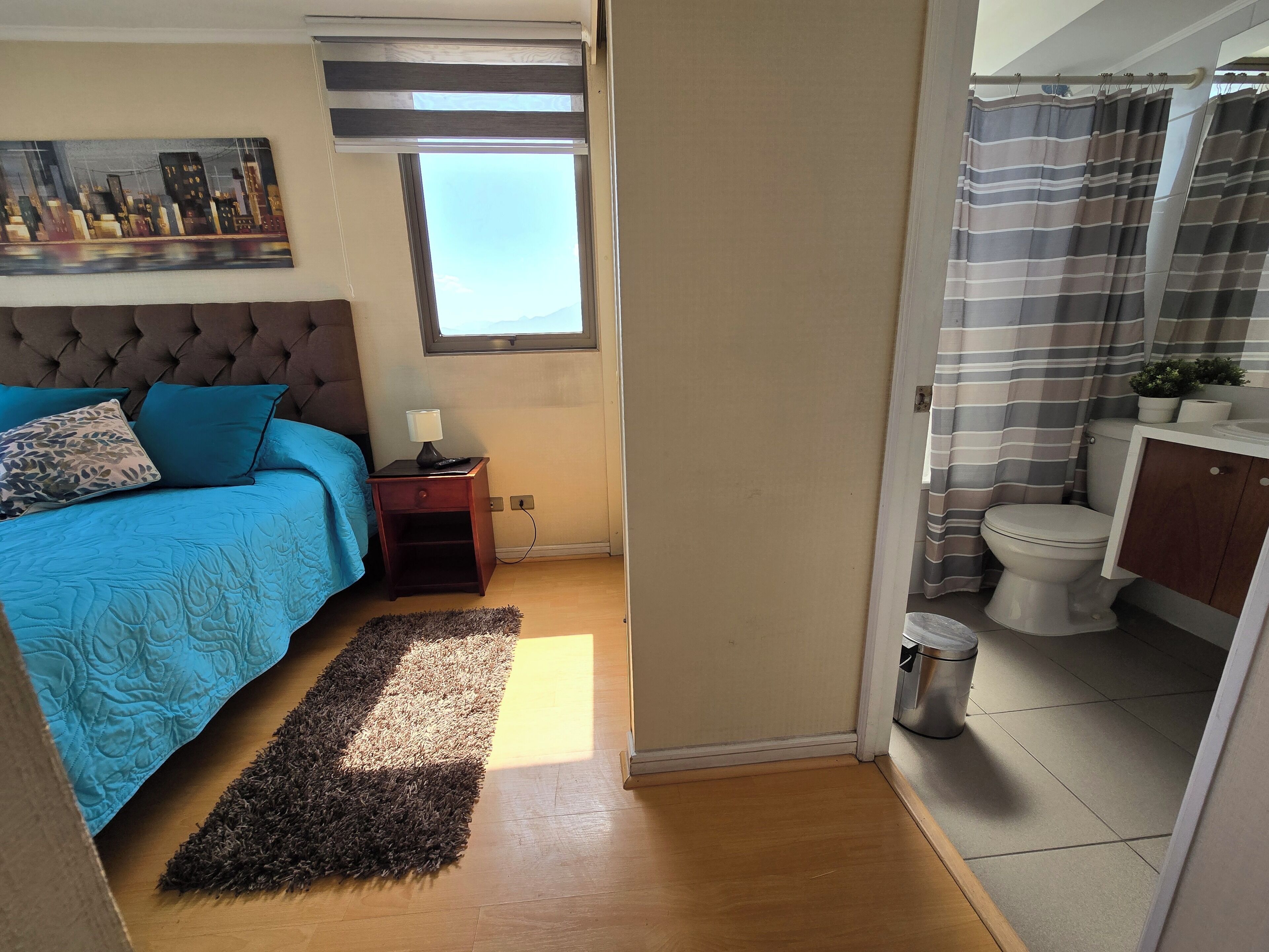 Une chambre à coucher avec un lit, une table de chevet et une fenêtre.
