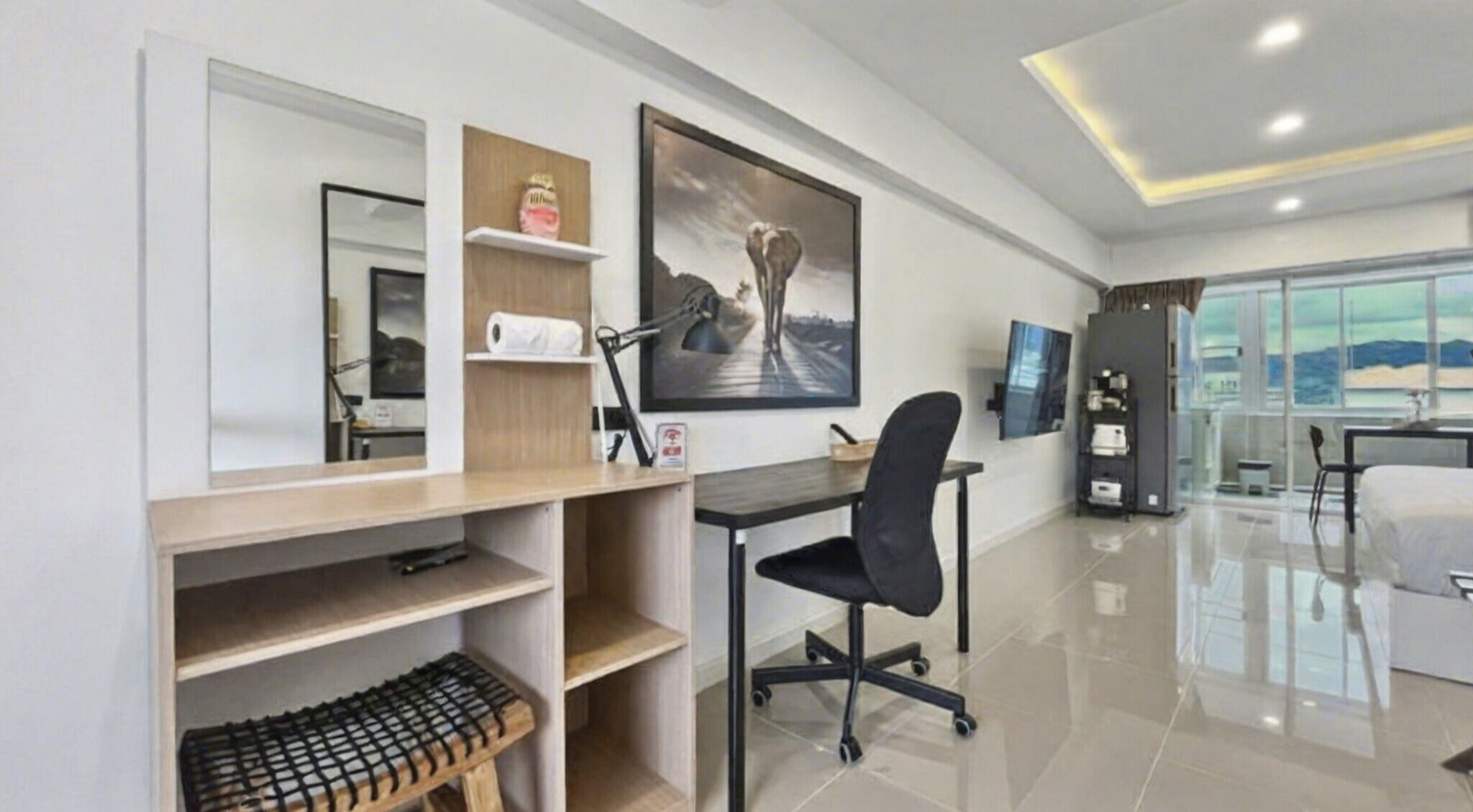 Habitación de hotel moderna con escritorio, silla y un amplio ventanal con vistas a la ciudad.