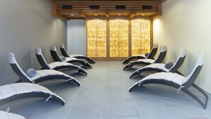 A room with reclining chairs arranged in a semi-circle, a large window with a patterned view, and a wooden ceiling. - Apartment Near ski Area (Treffen)