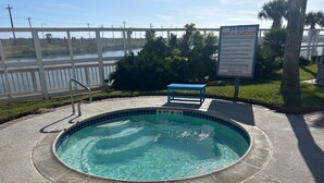 Uma piscina com um aviso indicando 'NORMAS DO SPA' e 'ATENÇÃO - SEM SALVAVIDAS'