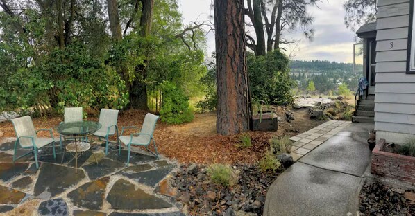 A patio with stone flooring, a glass table, and four chairs. - Garden Bodega on Sunset Ridge, Near Downtown, Hot tub, all with Panoramic View (Spokane)