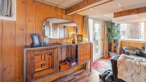 A cozy room with wooden walls, a large mirror, a black leather chair, and a small table with decorative items. - Garden Bodega on Sunset Ridge, Near Downtown, Hot tub, all with Panoramic View (Spokane)