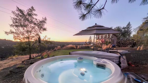 A hot tub with a wooden deck, surrounded by trees and a gazebo. - Garden Bodega on Sunset Ridge, Near Downtown, Hot tub, all with Panoramic View (Spokane)