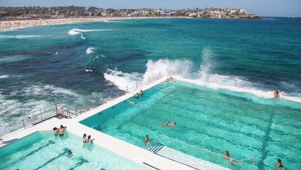 A swimming pool adjacent to a beach with waves crashing onto the shore. - Beautiful, Large Bondi Room with Private Ensuite (Bondi Junction)