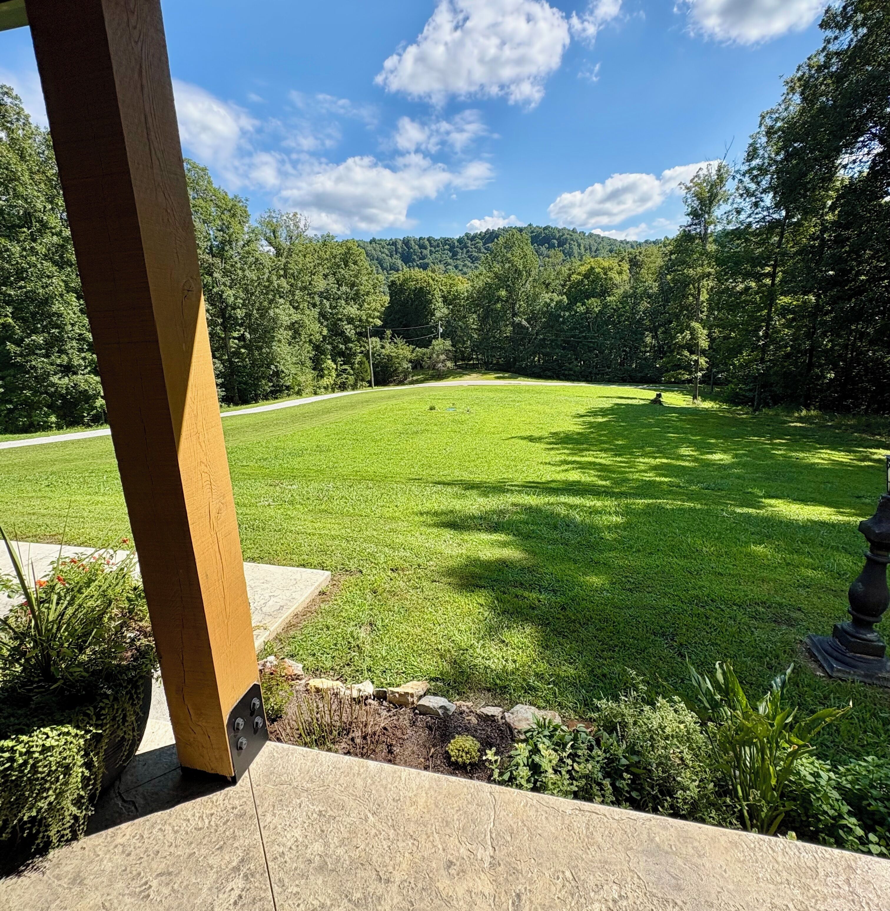 A well-maintained lawn with a stone pathway leading to a wooden structure.