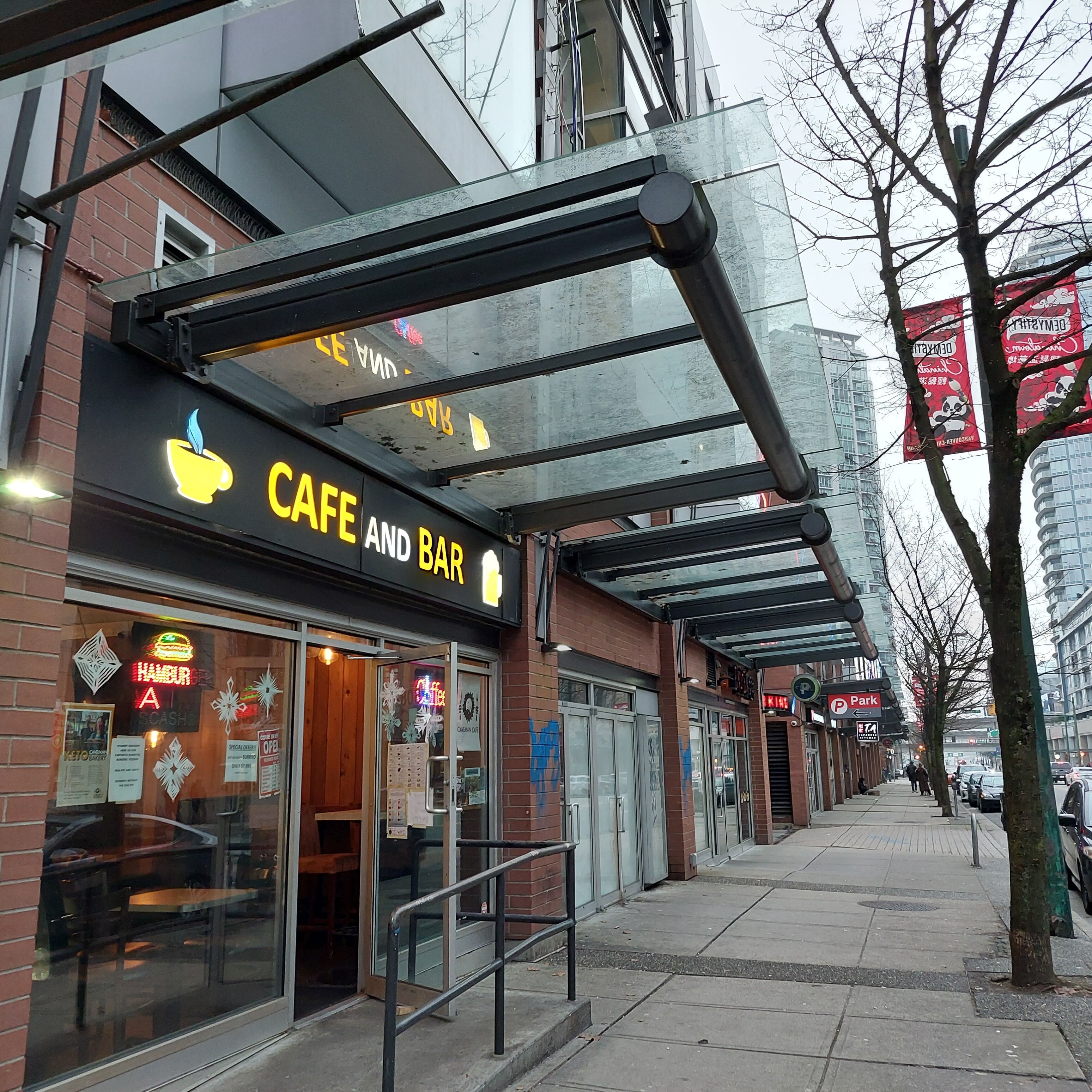A cafe and bar with a glass storefront and outdoor seating area.