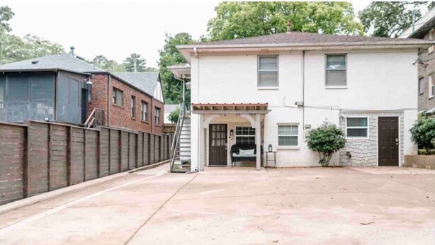 A two-story residential building with a garage, a covered entryway, and a small front yard.