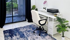Un espacio de oficina moderno con escritorio, silla, impresora y plantas en macetas.