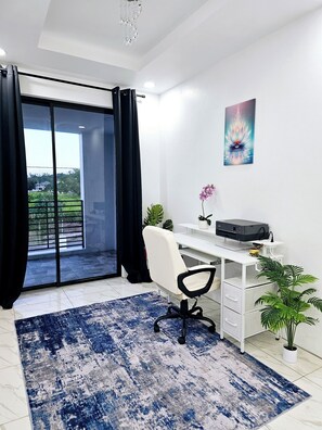 Un espacio de oficina moderno con escritorio, silla, impresora y plantas en macetas.