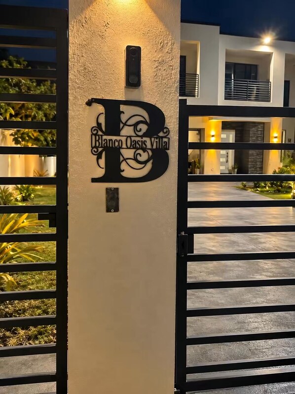 A gated entrance with a sign reading 'Blanco Oasis Villa.'