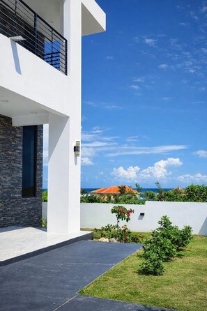 A modern two-story building with a stone facade and a flat roof. - Modern Oceanview Villa. All Bedrooms with Private Bathrooms. Private Pool (St. Ann Parish)