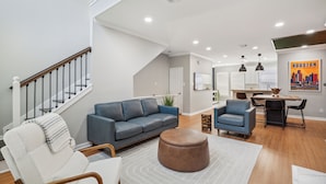 A spacious living room with a staircase, a dining area, and a kitchen. - 5 Minutes to Downtown + GARAGE! Near Med Center/NRG/George R Brown Convention (Houston)