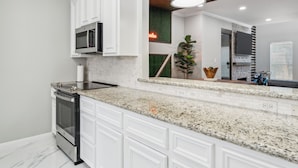 A modern kitchen with white cabinetry, granite countertops, a built-in oven, and a microwave. - 5 Minutes to Downtown + GARAGE! Near Med Center/NRG/George R Brown Convention (Houston)