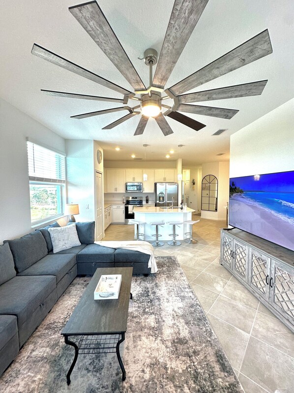 Relax in this stylish living space with a comfortable sofa, TV, and kitchen area.