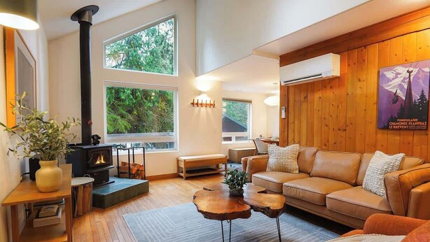 A cozy living room with a fireplace, wooden furniture, and large windows. - Cozy Mt. Baker Escape • Fireplace • Pets (Glacier)