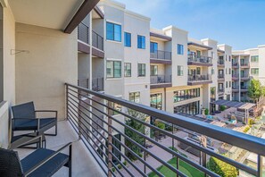 A modern apartment building with balconies, outdoor seating, and a courtyard. - ROVE LIVING/KL - Alta North Central (Phoenix)