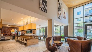 A modern kitchen with a central island, bar seating, and a dining area with leather chairs. - ROVE LIVING/KL - Alta North Central (Phoenix)