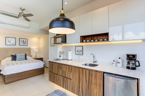 A modern bedroom with a wooden bed, a built-in desk, and a coffee machine. - Casa Azul New Deluxe Studio Apt w/Great Views, Pool & Jacuzzi (Nuevo Nayarit)