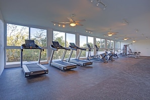 A gym with treadmills, ceiling fans, and large windows. - Casa Azul New Deluxe Studio Apt w/Great Views, Pool & Jacuzzi (Nuevo Nayarit)