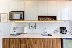 A modern kitchen with a built-in microwave, a coffee maker, and a sink. - Casa Azul New Deluxe Studio Apt w/Great Views, Pool & Jacuzzi (Nuevo Nayarit)