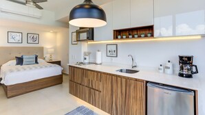 A modern bedroom with a wooden bed, a built-in desk, and a coffee machine.
