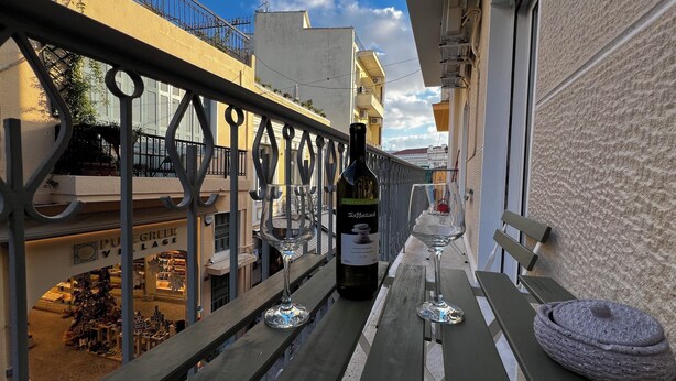 Ein Balkon mit einer Weinflasche, einem Glas und einer Kerze.