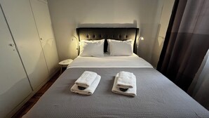 Ein Hotelzimmer mit einem Bett, zwei weißen Handtüchern, einem Nachttisch und einem Kopfteil.