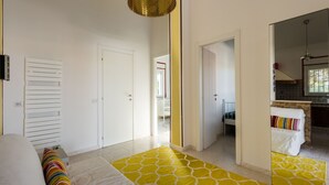 Un dormitorio con una cama, un tapete amarillo estampado y una puerta blanca.