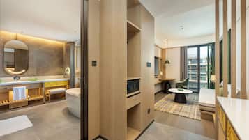 Un baño de hotel moderno con bañera, tocador y un espejo grande.