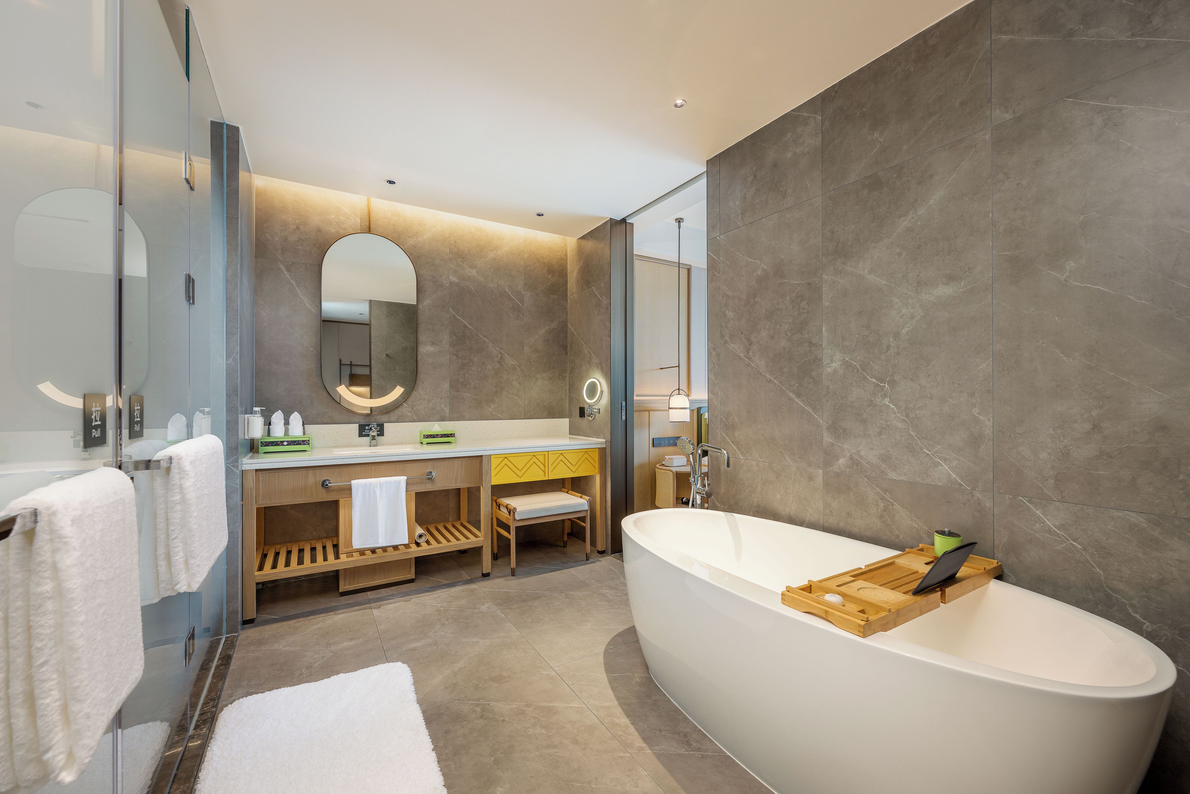 Ein modernes Badezimmer mit einer freistehenden Badewanne, einem Waschtisch mit Spiegel und einem Handtuchhalter.