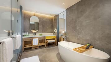 Ein modernes Badezimmer mit einer freistehenden Badewanne, einem Waschtisch mit Spiegel und einem Handtuchhalter.