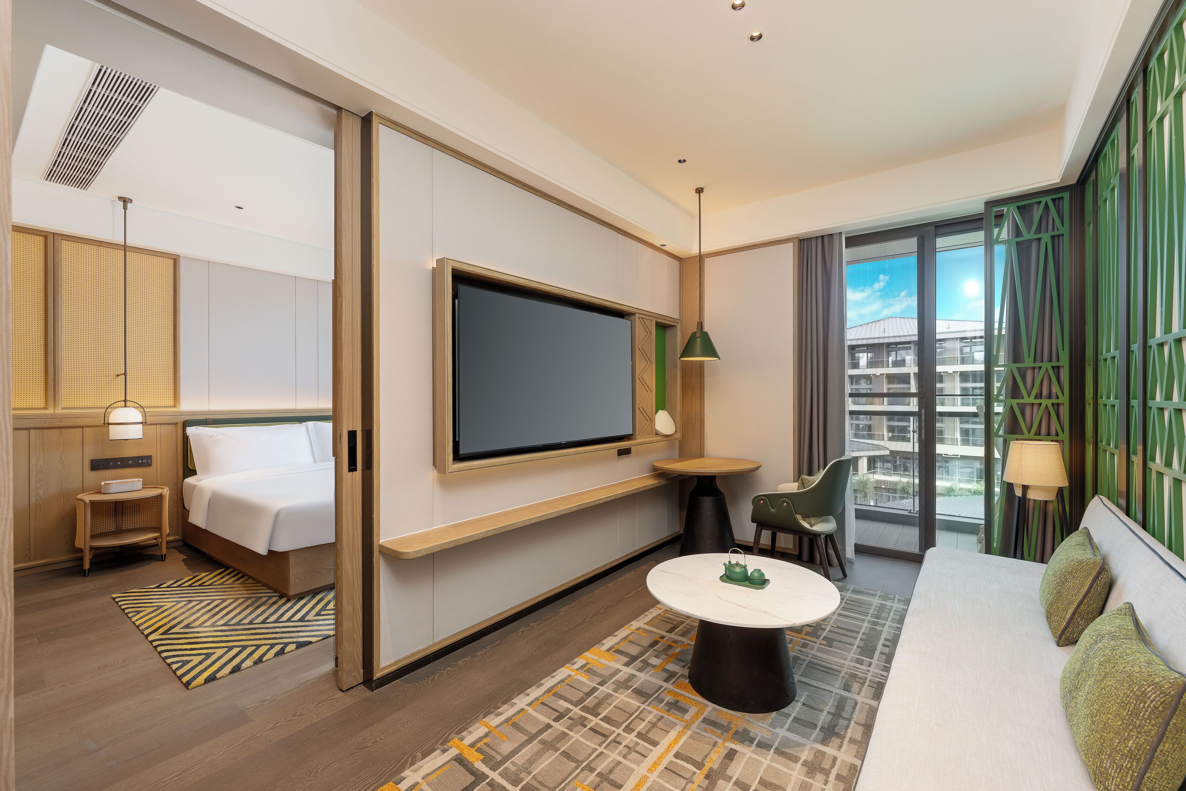 Habitación de hotel con cama, televisión, mesa, silla y vistas a la ciudad.